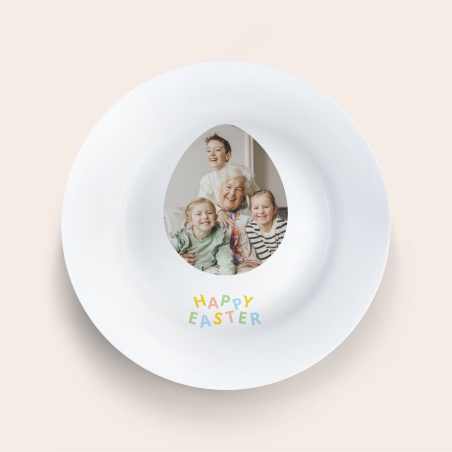 Velikonoční talíř Bílý velikonoční talíř s tiskem fotografie rodiny ve tvaru vejce a nápisem Happy Easter.