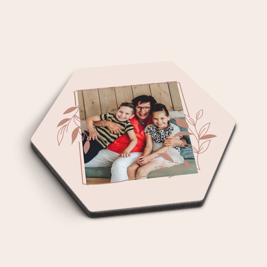 Untersetzer mit Foto Sechseckiger personalisierter Untersetzer mit aufgedrucktem Foto einer lachenden Frau und zwei Kindern, verziert mit Blättern.
