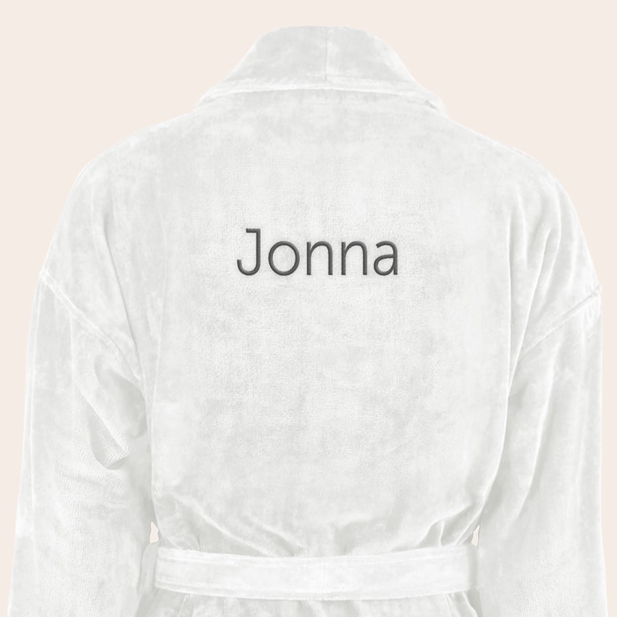 Badrock Dam med namn Vit mjuk badrock med namn Jonna broderat i svart på ryggen, en badrock broderad med din egen text