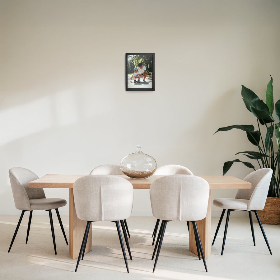 Foto in lijst bestellen Gepersonaliseerde fotoafdruk met een zwart houten lijst, geprint met een foto van een volwassene en een kind op een skateboard.