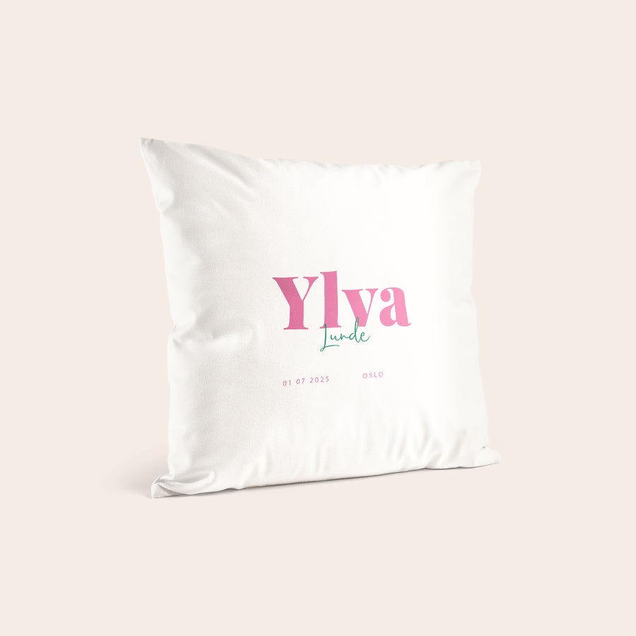Fødselspute Hvit fødselspute med navn, Ylva Lunde, trykt i rosa og turkis skrift, med dato 01 07 2025 og Oslo.