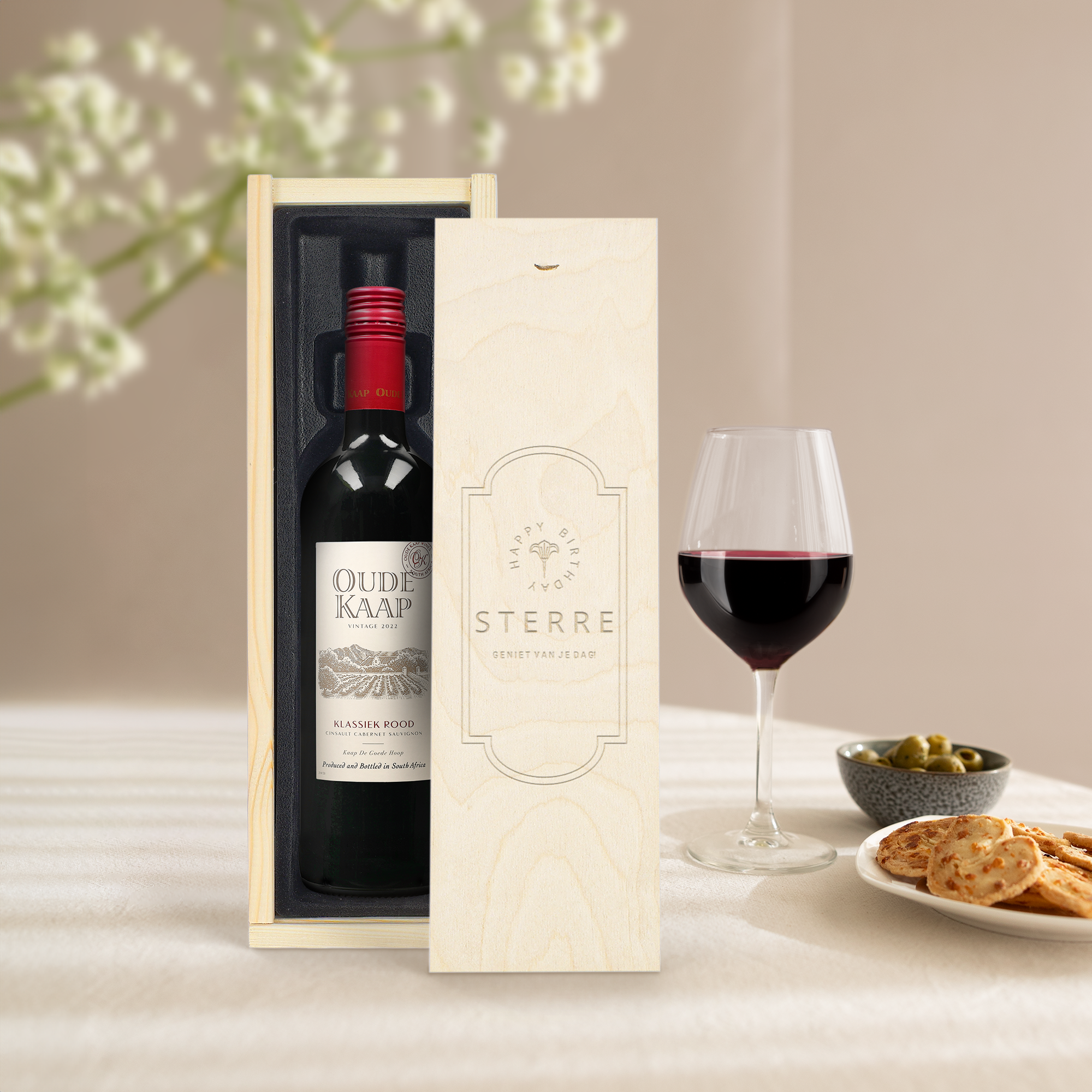 Fles Oude Kaap rode wijn in een houten gegraveerde wijnkist met de tekst Sterre Geniet Van Je Dag