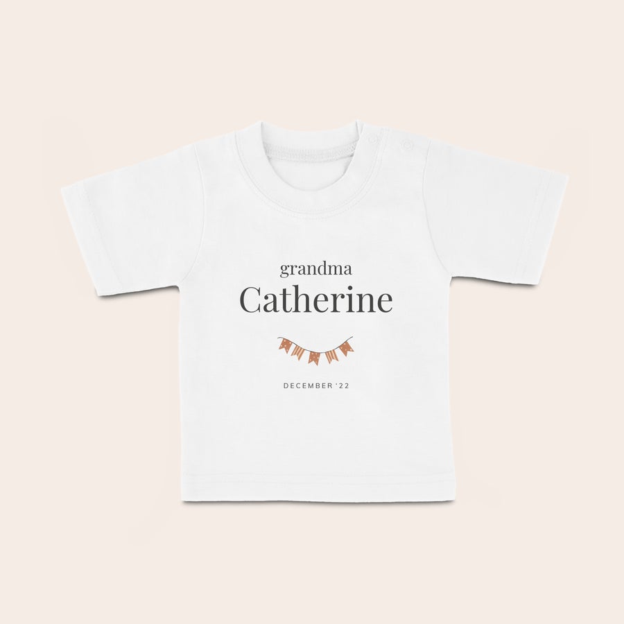 Baby T-shirt Vit babyskjorta med tryckt text grandma Catherine och datum december 22 med vimpelband. Ditt lilla barn blir så fin.