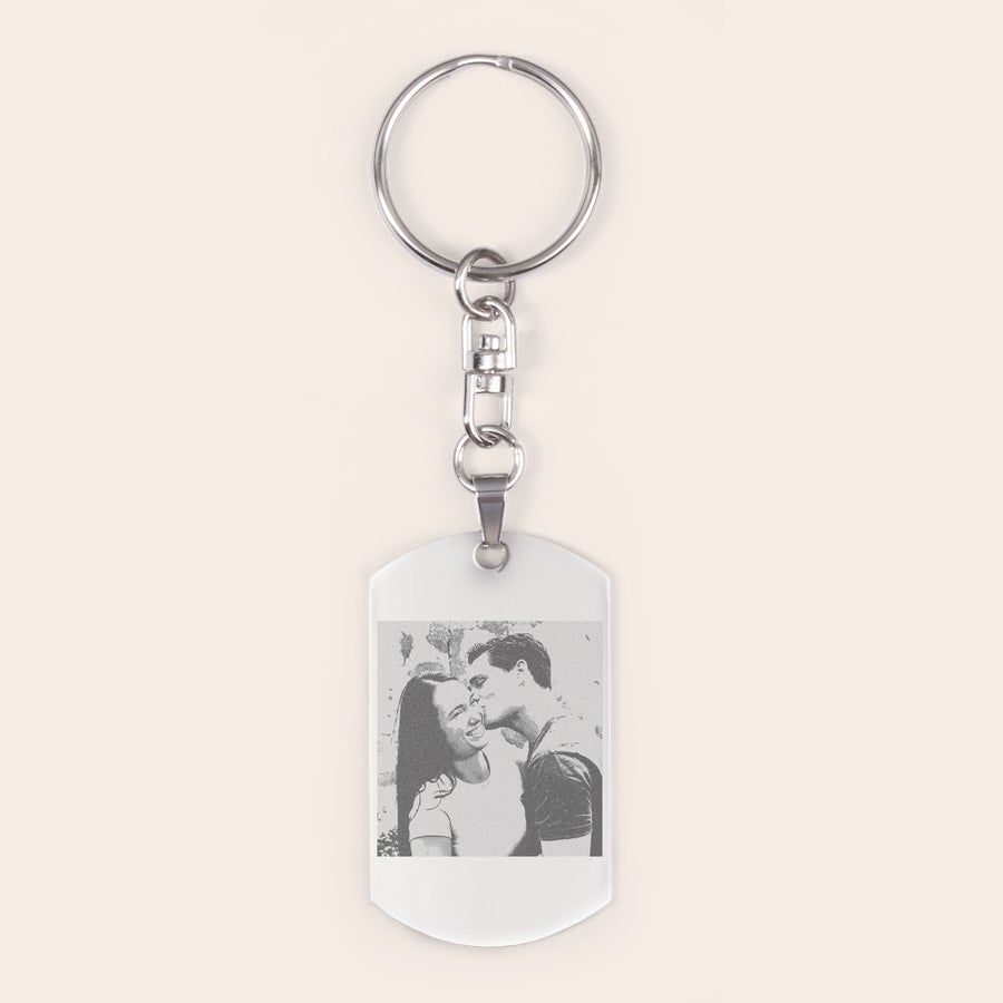 Sleutelhanger graveren Zilverkleurige sleutelhanger met een gegraveerde foto van een zoenend stel, voor een persoonlijke touch aan je sleutelbos.