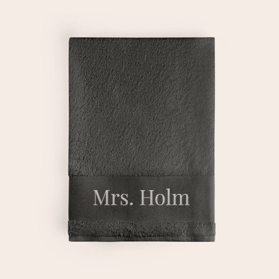 Håndklæde med tekst Blødt mørkegråt håndklæde broderet med navnet Mrs. Holm