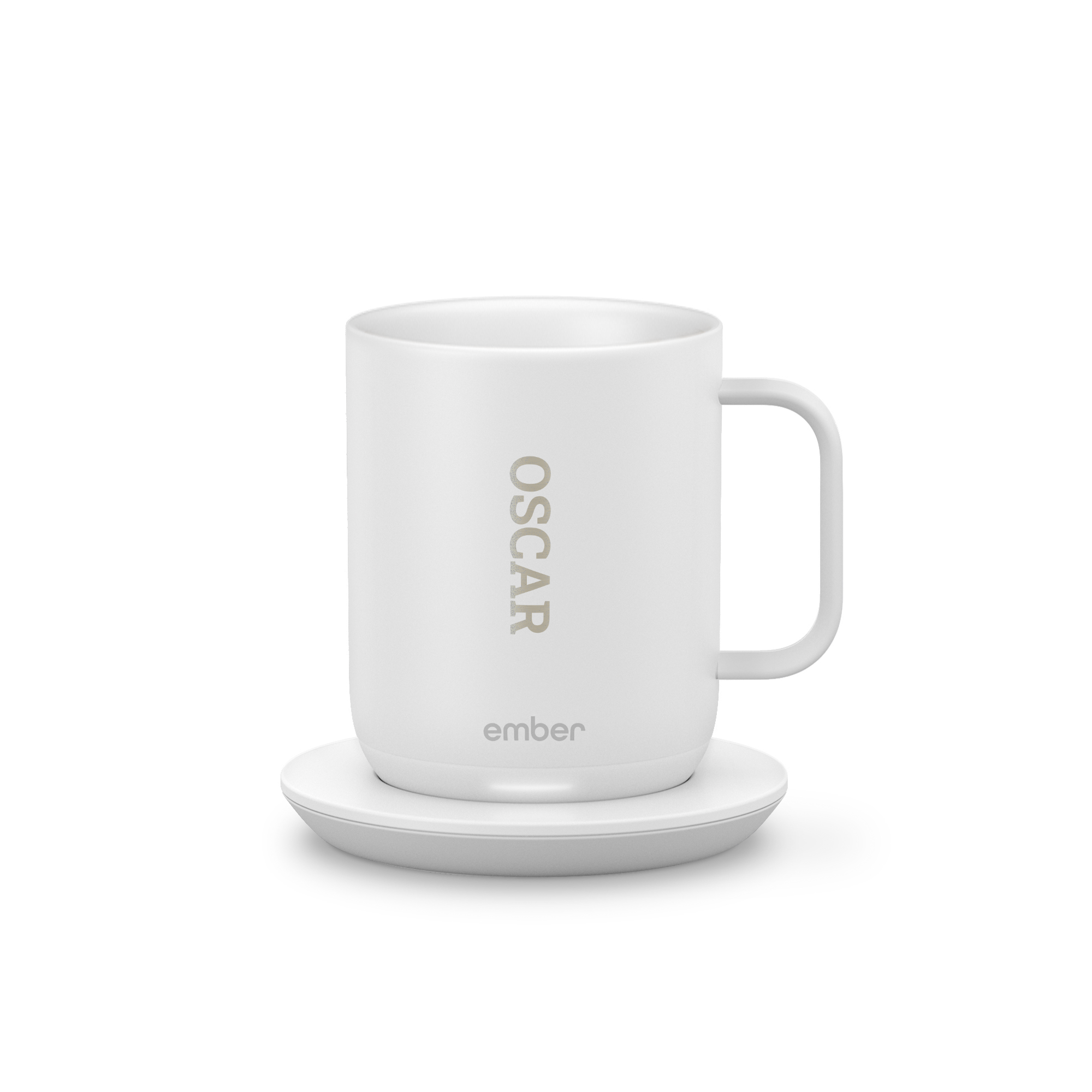 Hvit personlig Ember Control Cup med navnet "OSCAR" lasergravert, på ladestasjon, nyt hver slurk.