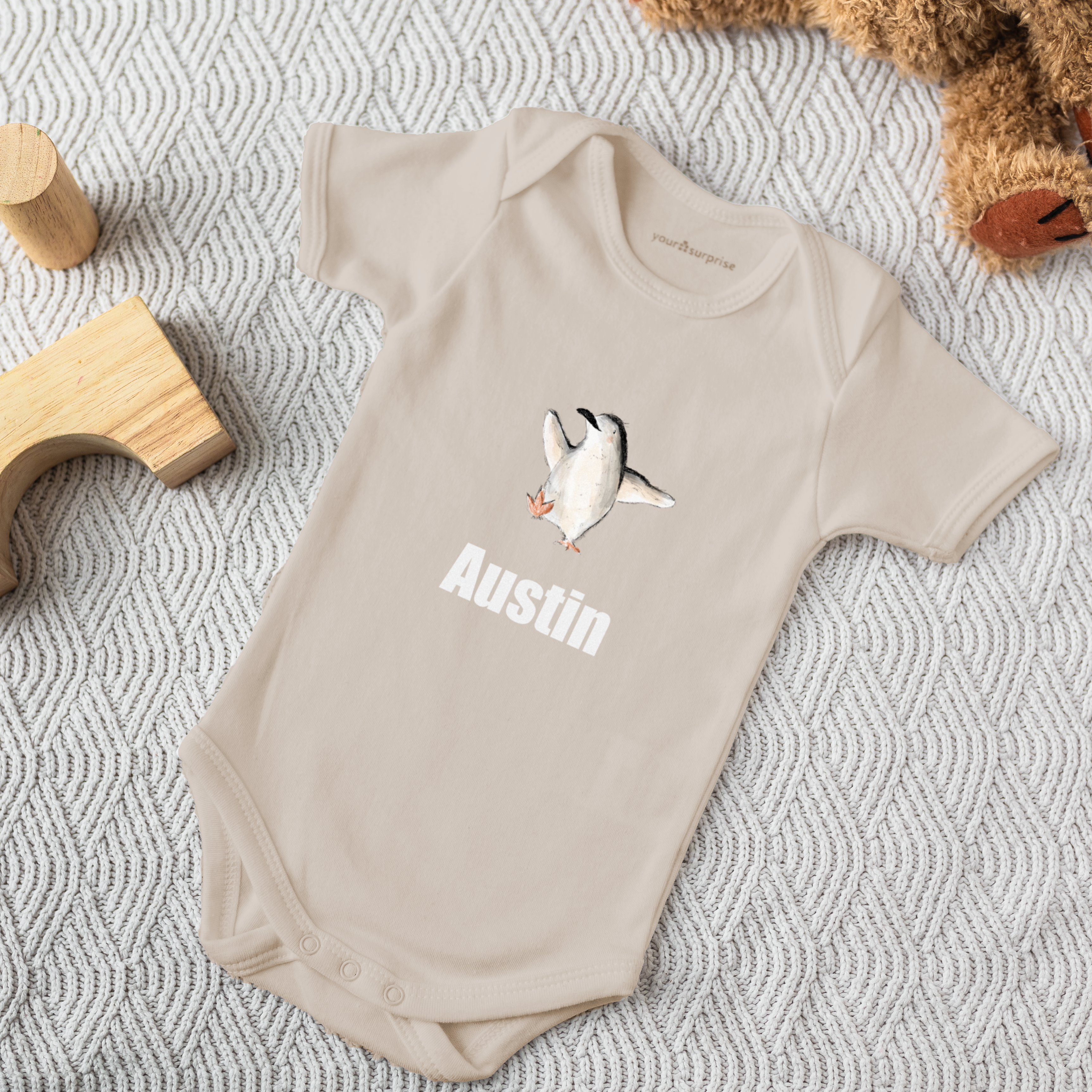 Beige babygrow printed with a penguin and personalized with the name Austin to surprise new parents