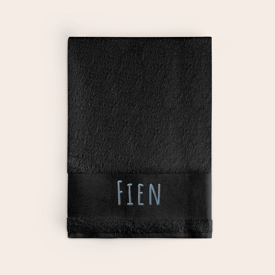 Handdoek met naam Zwarte handdoek met de naam 'FIEN' in lichtblauw borduursel. Personaliseer de handdoek met een naam geborduurd.