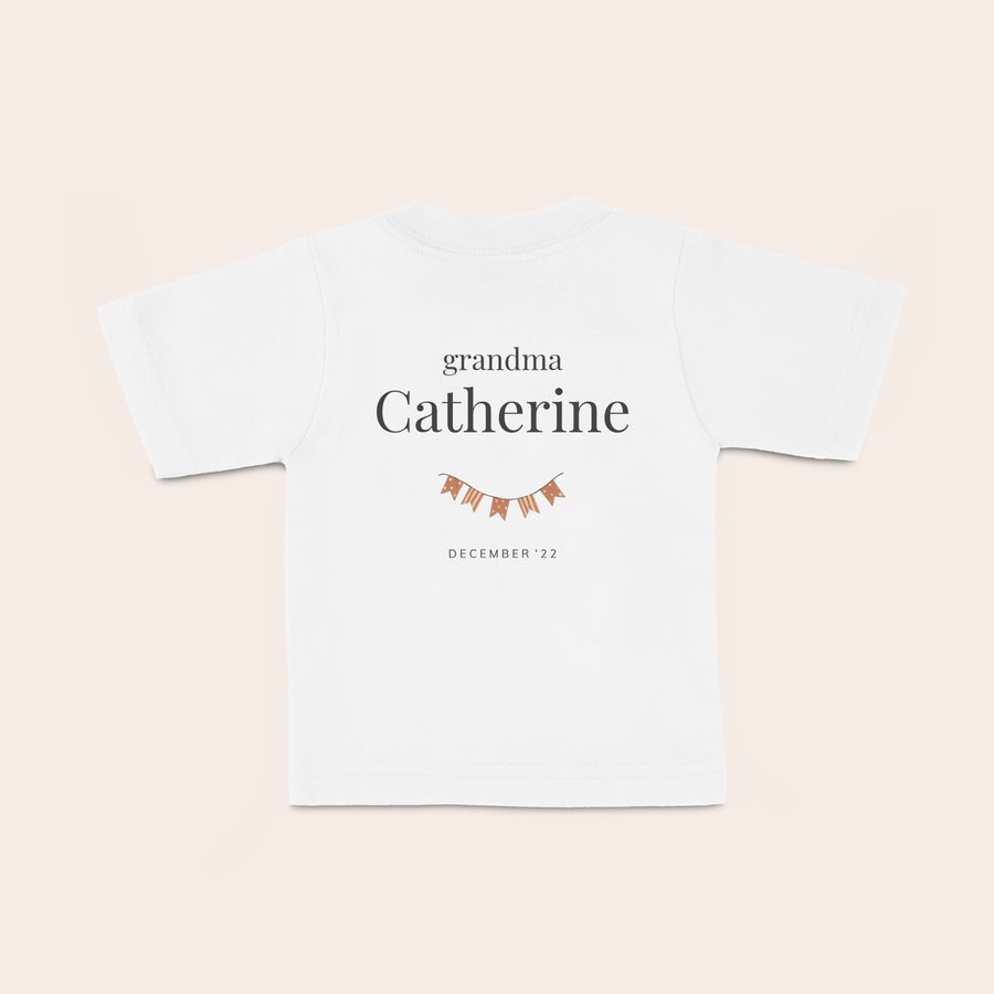 Baby T-shirt Vit babyskjorta med tryck av "grandma Catherine" en girland och "December 22". Ditt lilla barn blir så fin i en glad babyskjorta med ett namn.