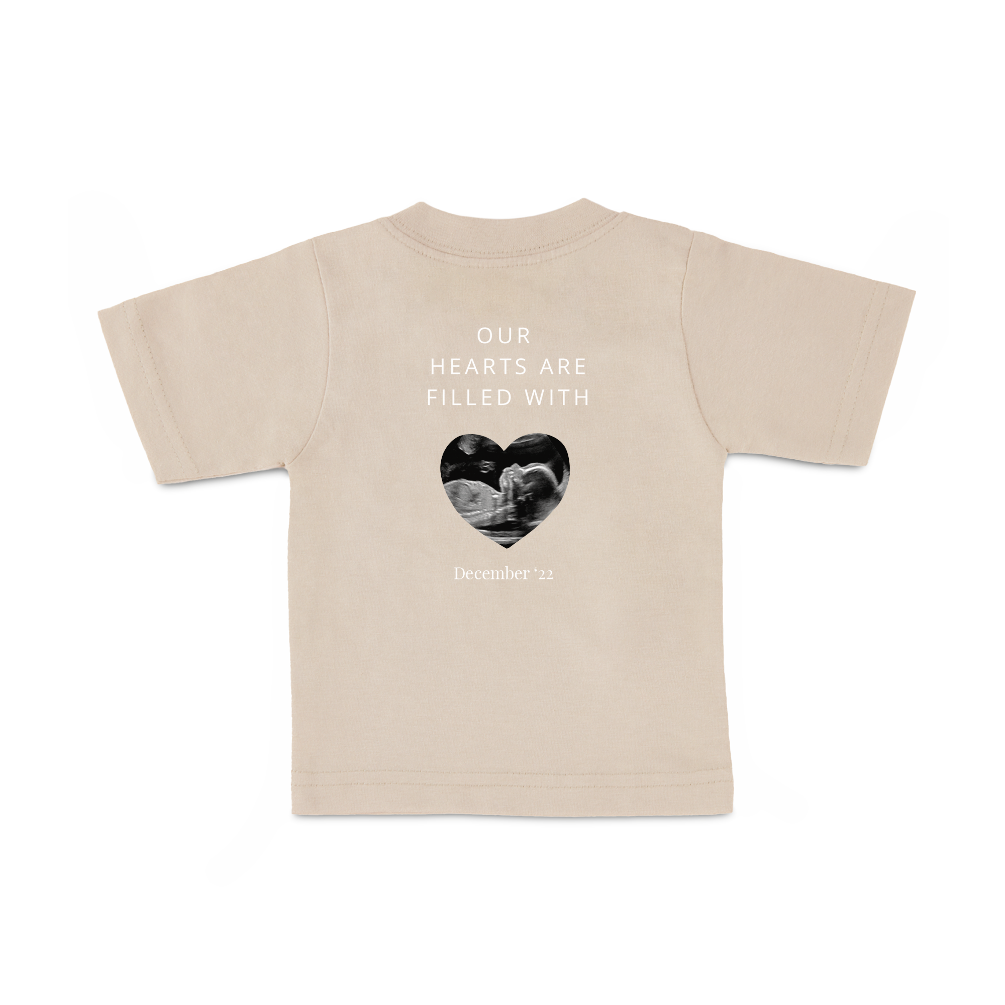 Babyskjorta i beige med tryckt ultraljudsbild och texten Our Hearts Are Filled With samt datumet December '22.