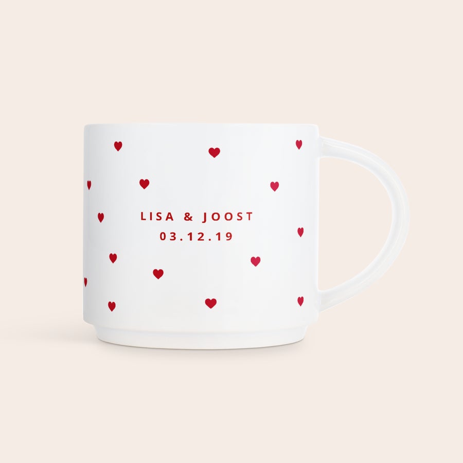 Stapelbare mokken bedrukken Witte stapelbare fotomok bedrukt met rode hartjes en de namen Lisa & Joost en de datum 03.12.19. Maak van elke slok iets speciaals met je persoonlijke stapelbare fotomok.