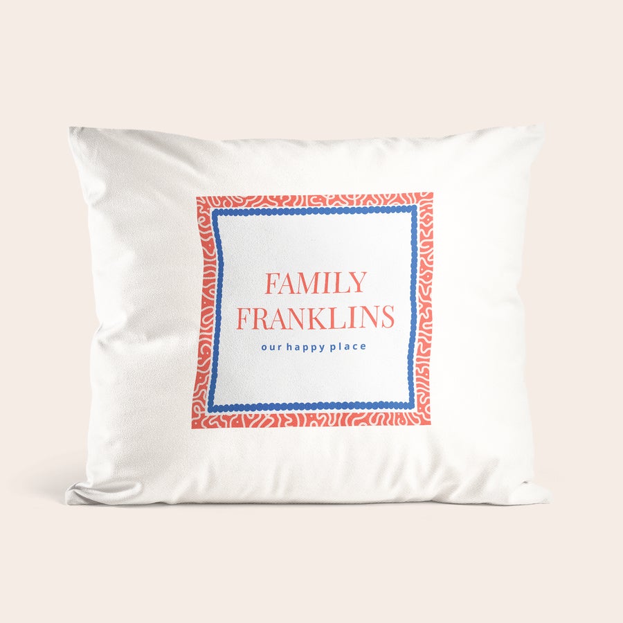 puter Hvit pute trykt med navn Familie Franklins og teksten "our happy place", omgitt av en rød og blå ramme.