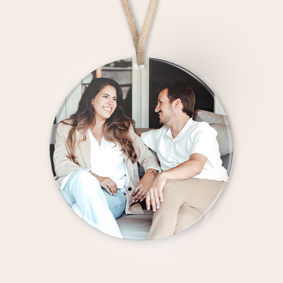 Personalizirani božični okraski iz pleksi stekla Okrogel personaliziran božični okrasek iz pleksi stekla z natisnjeno fotografijo smejočega se para, ki sedi na kavču.