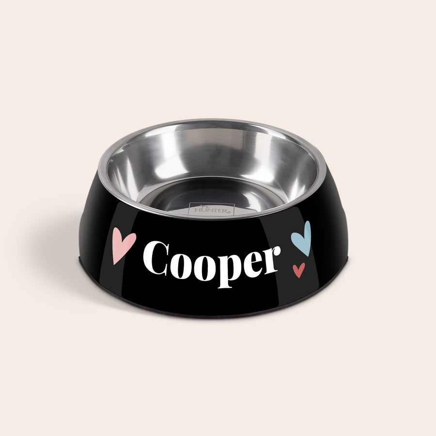 Comedero - Perros Comedero personalizado negro con un cuenco de acero inoxidable, el nombre "Cooper" impreso y corazones de colores.