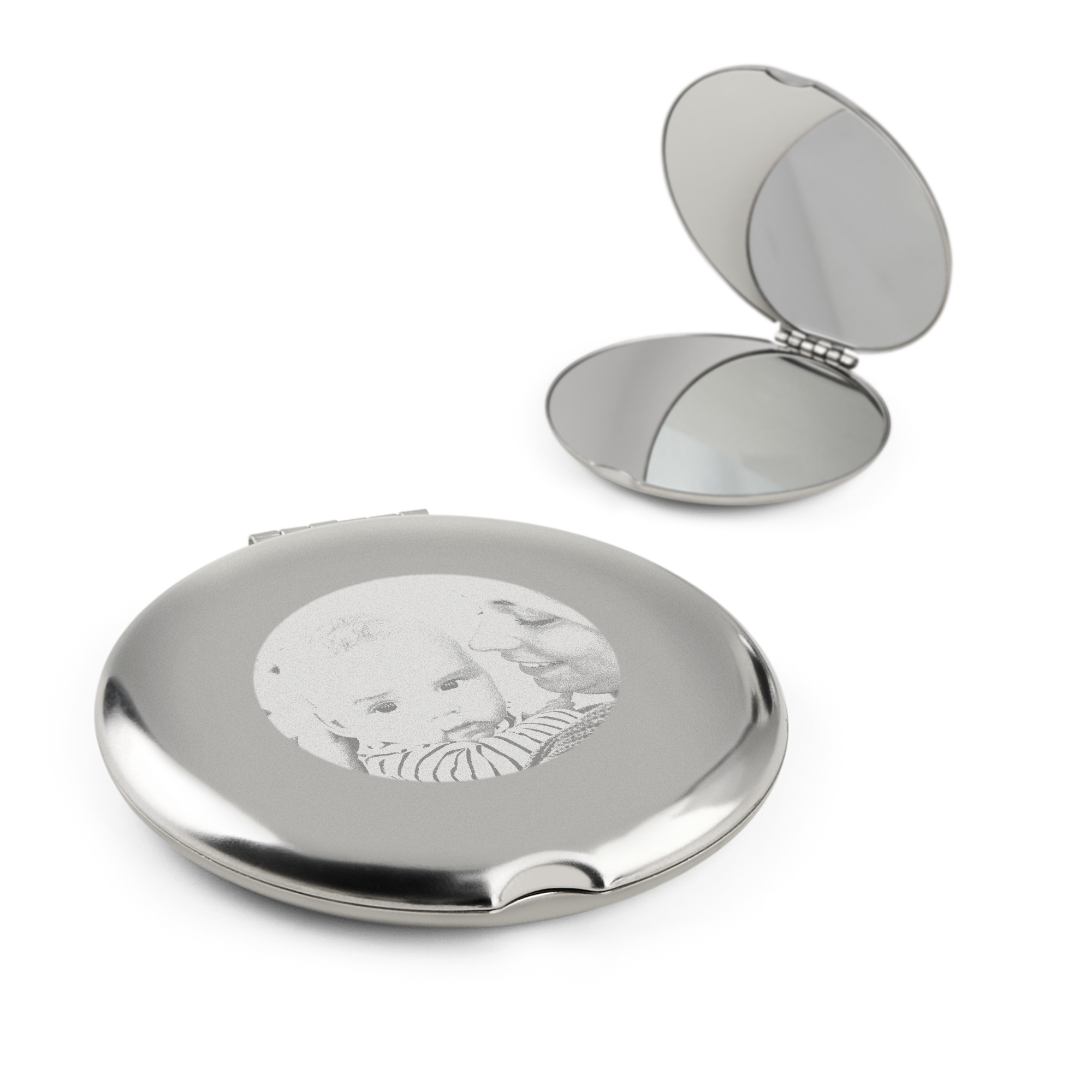 Twee zilverkleurige make-up spiegels, waarvan één gegraveerd met een foto van een moeder en baby.