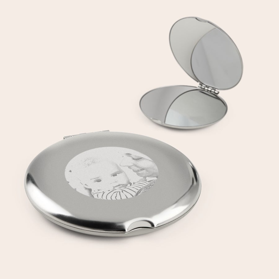 Spiegel bedrukken Twee zilverkleurige make-up spiegels, waarvan één gegraveerd met een foto van een moeder en baby.