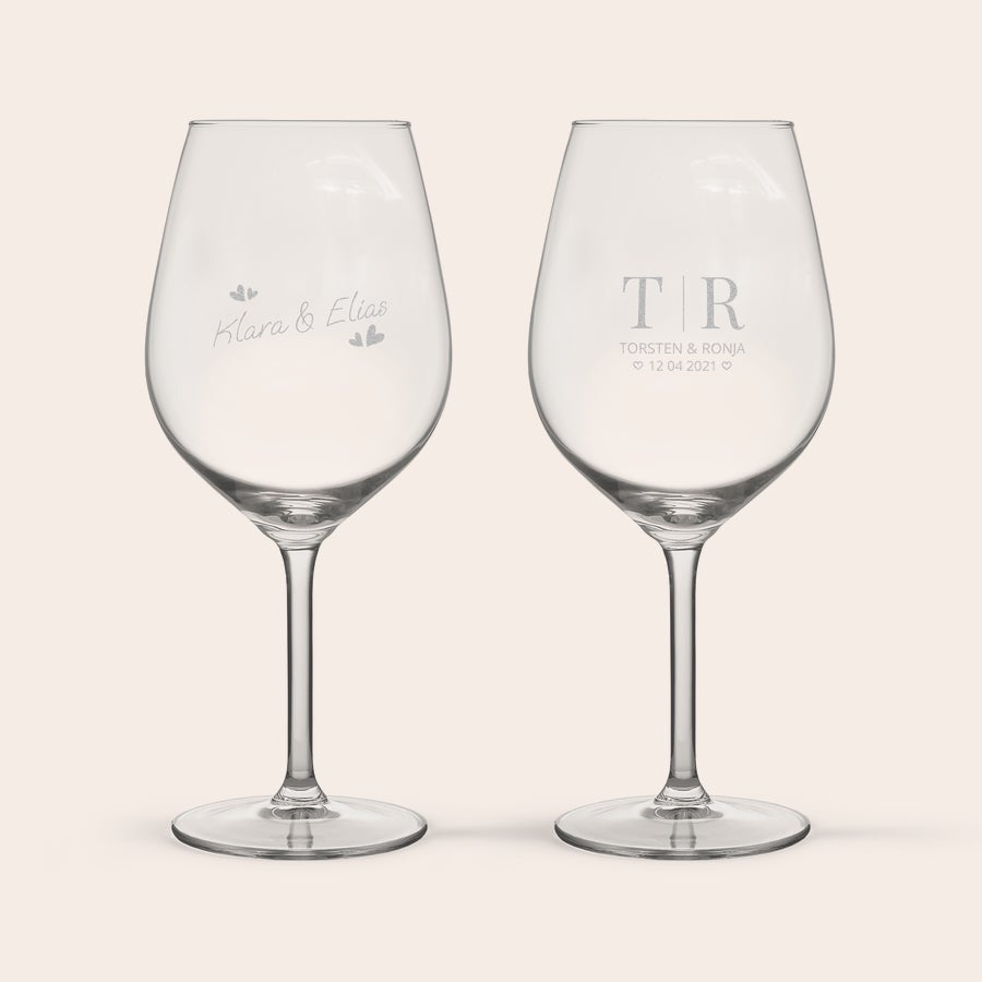 Rotweinglas mit gravur Zwei personalisierte Rotweingläser, eines graviert mit "Klara & Elias" und Herzen, das andere mit "TR", "Torsten & Ronja" und dem Datum "12 04 2021".