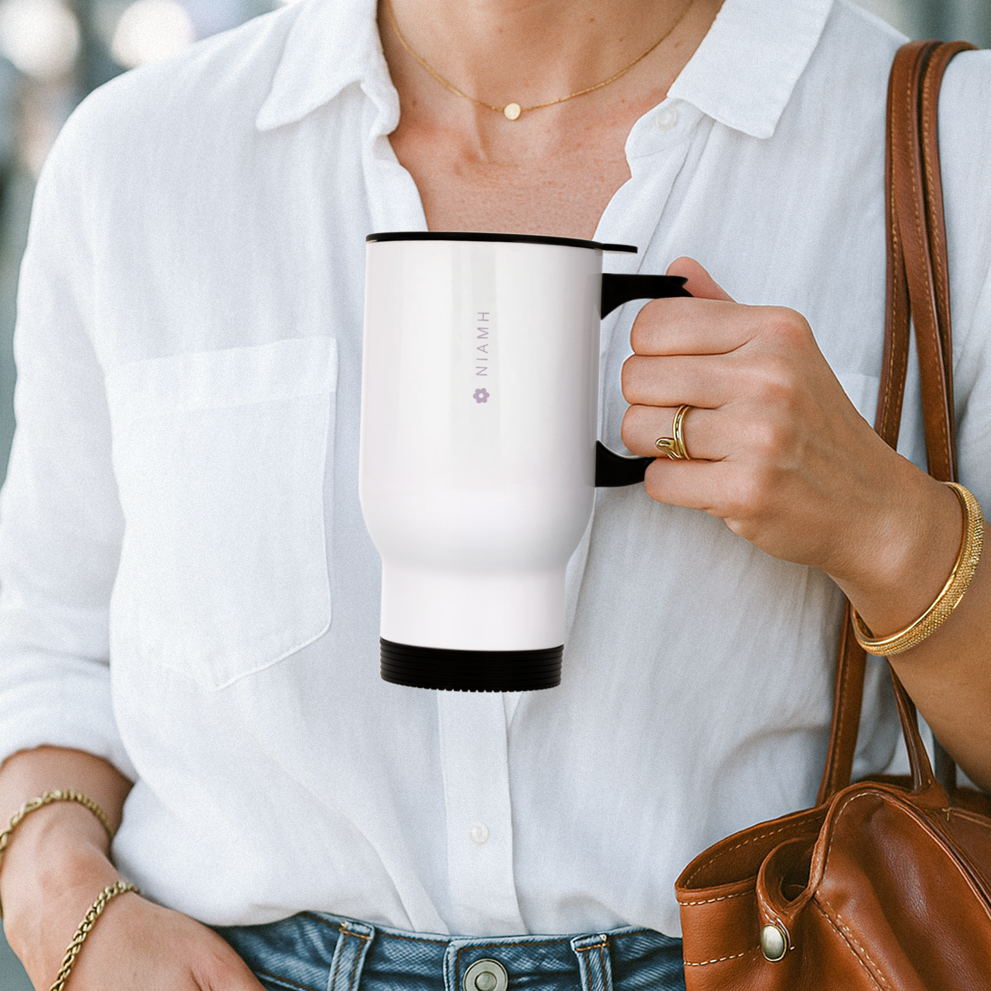 White custom thermos mug with black handle, printed with the name NIAMH and a small flower icon, held by a person. Transform any daily drink with a custom touch.
