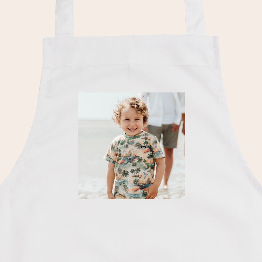 Kinderschürze personalisiert Weiße Kinderschürze mit einem Foto eines lachenden kleinen Jungen mit Locken bedruckt.