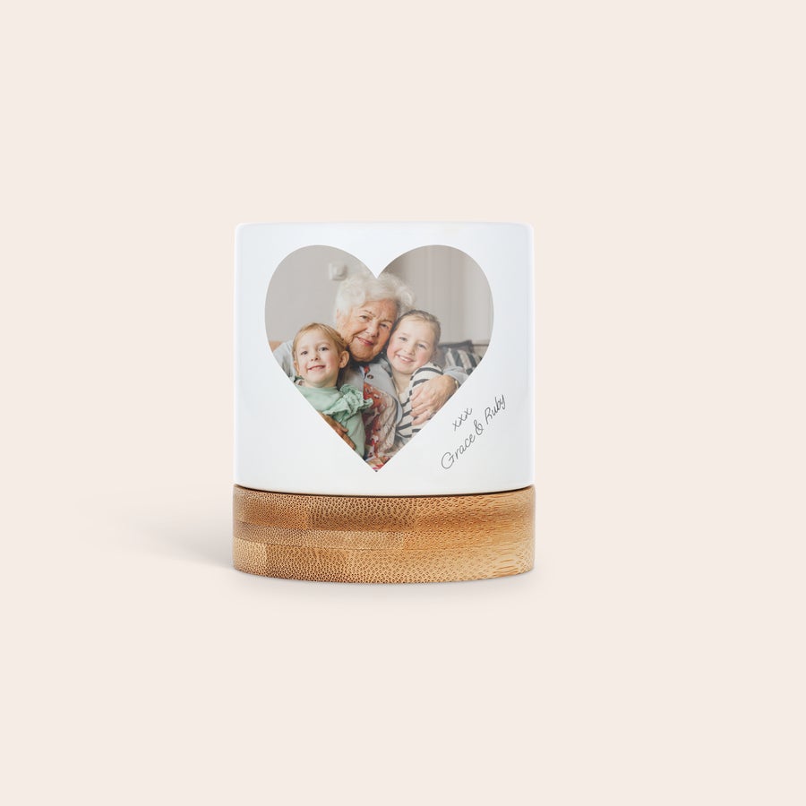 Personalised flower pot White personalized flower pot with a photo of a grandmother and two children printed in a heart shape, on a wooden base. Give them greenery with a personal touch.
