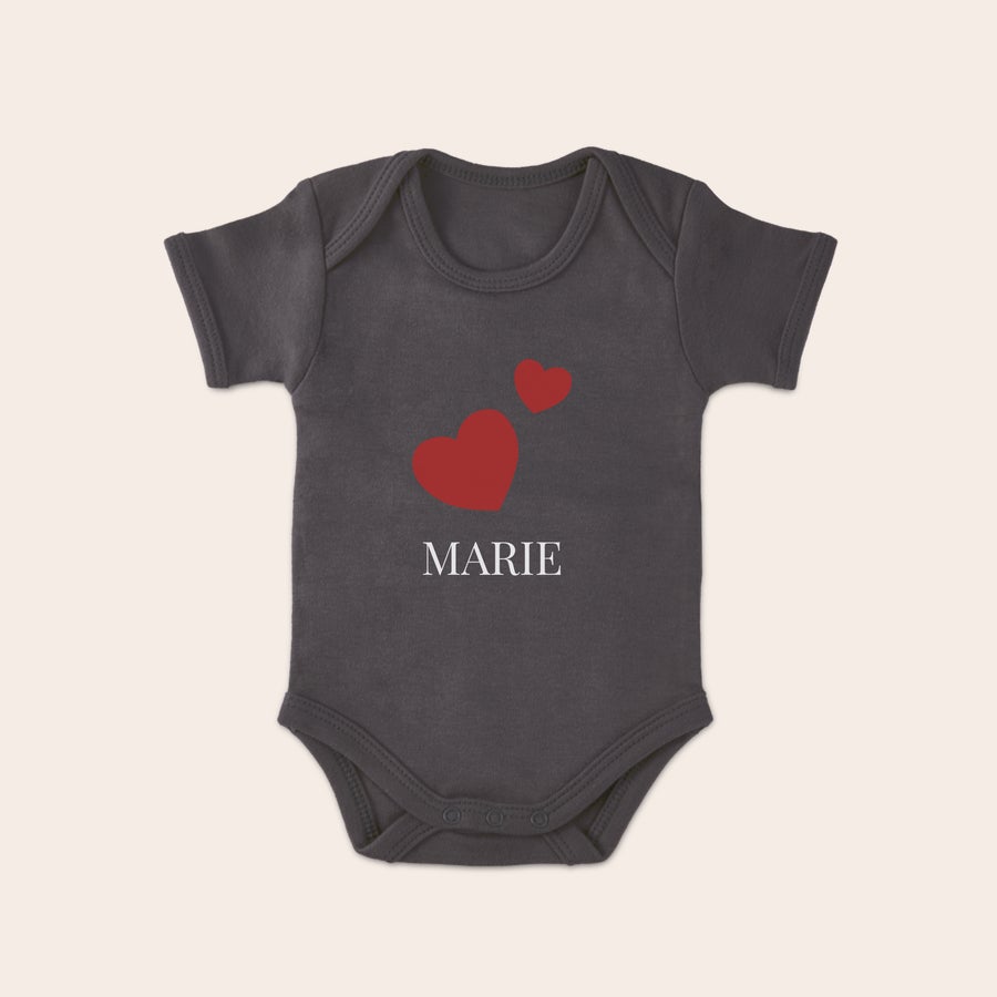 Baby Body bedrucken Grauer Babybody bedruckt mit dem Namen MARIE und zwei roten Herzen. So lässt sich ein origineller Babybody bedrucken.