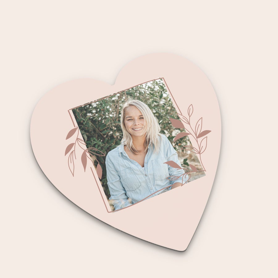 Untersetzer mit Foto Herzförmiger personalisierter Untersetzer mit Foto einer lachenden Frau, umrandet von stilisierten Blättern.