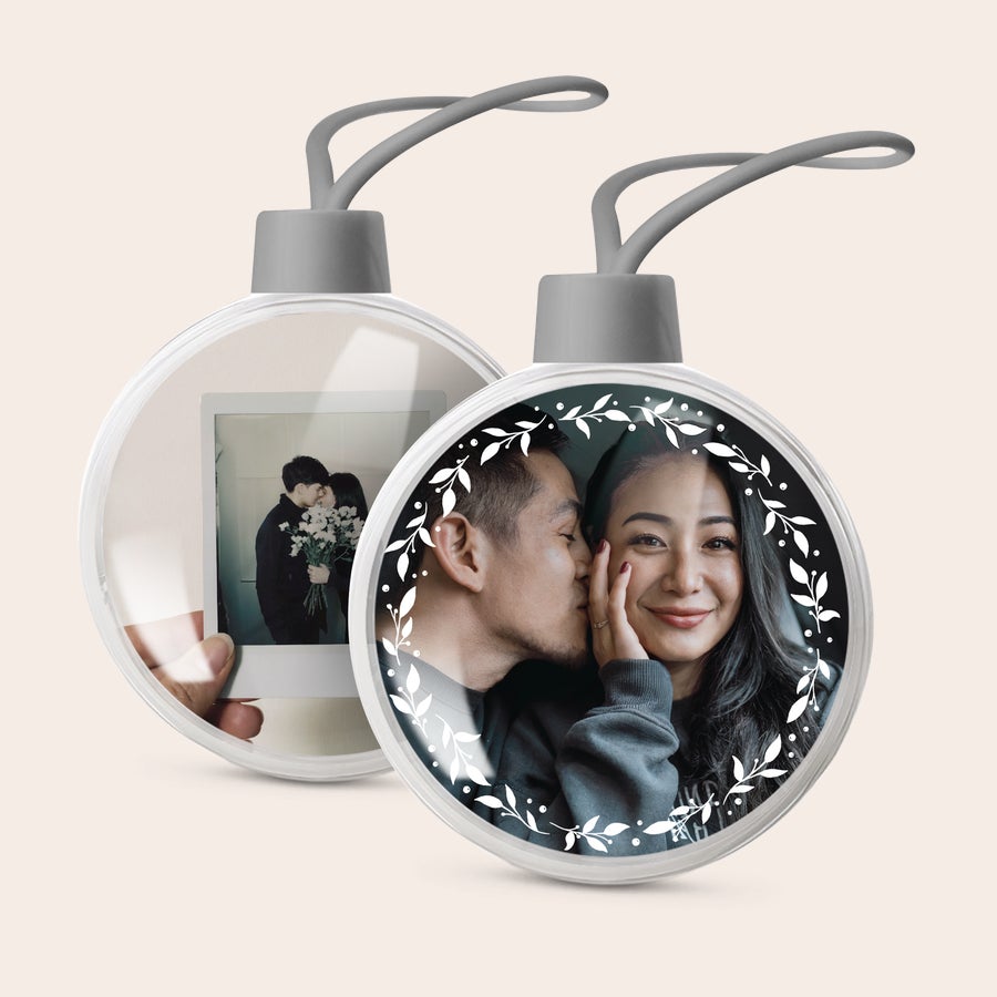 Gepersonaliseerde kerstbal Transparante, gepersonaliseerde kerstballen met eigen foto, gedecoreerd met witte blaadjes rondom.