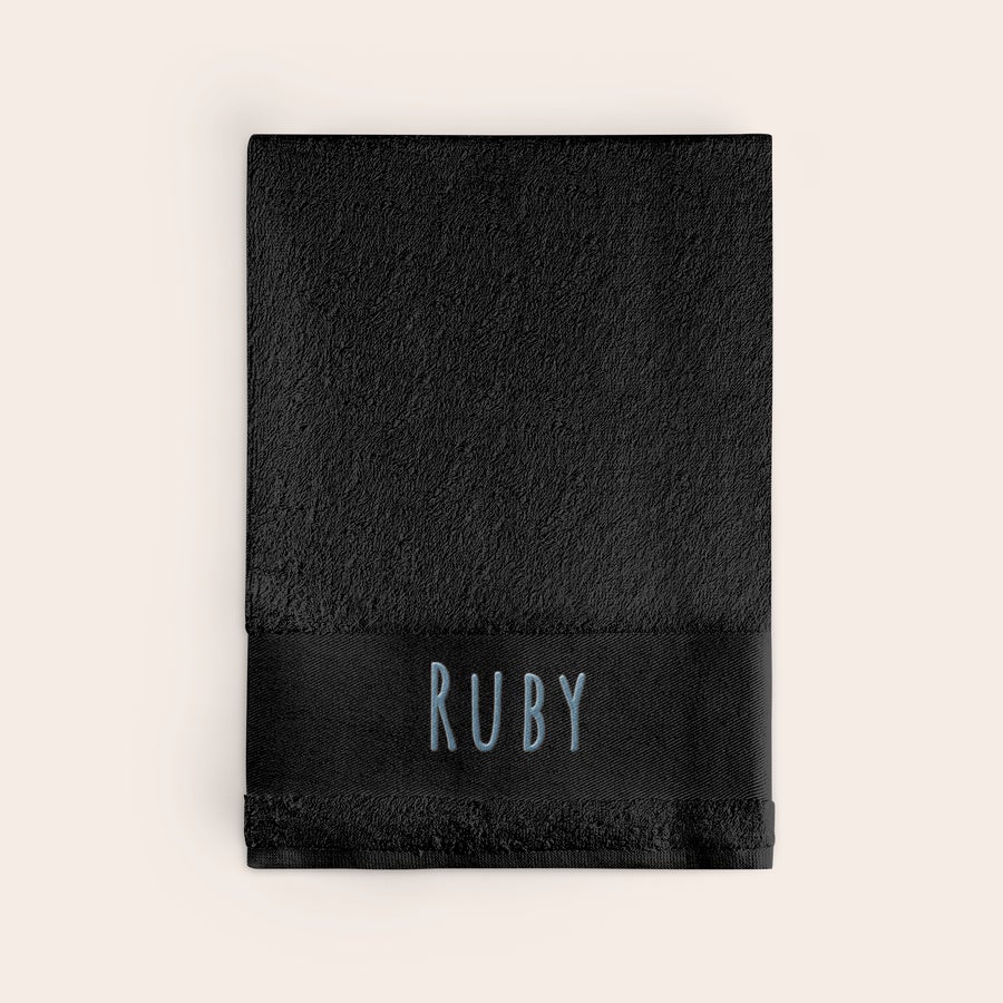Osuška s textem Personalizovaný černý ručník vyšívaný jménem RUBY modrou nití na okraji