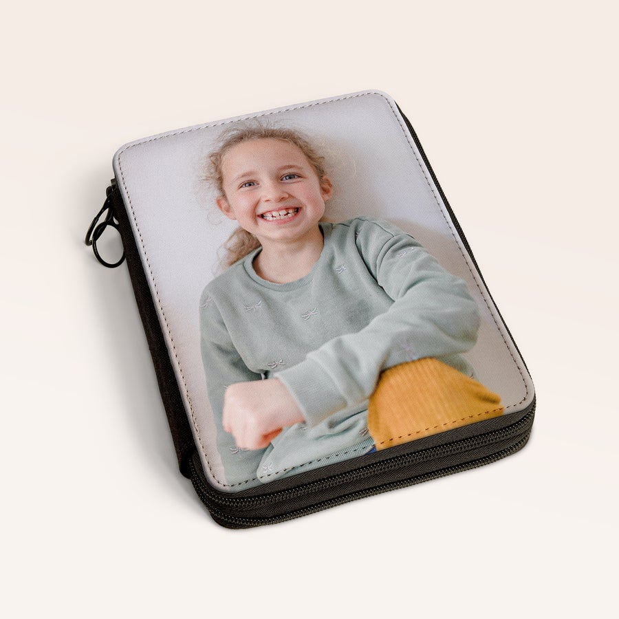 Astuccio a Piani personalizzato  Astuccio personalizzabile stampato con la foto di una bambina sorridente, con cerniera nera e portachiavi.
