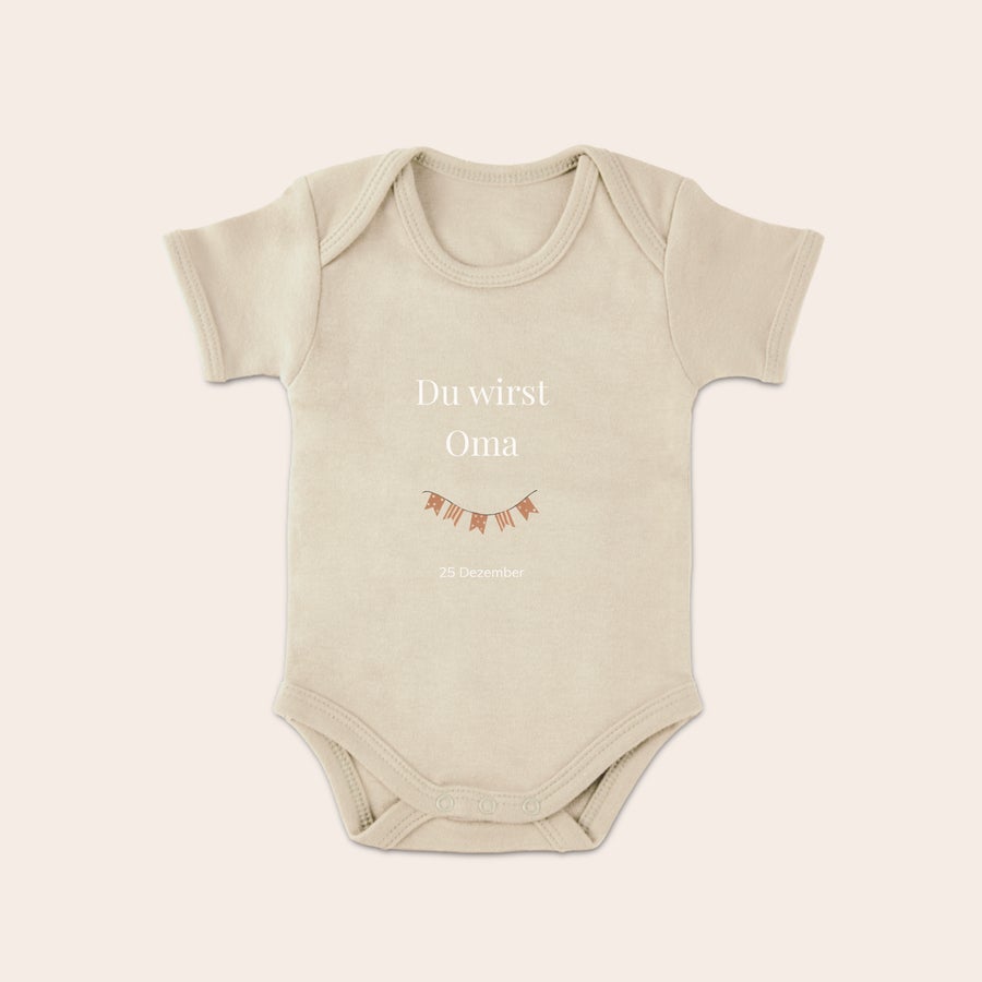 Baby Body bedrucken Beiger Babybody mit Aufdruck "Du wirst Oma" und Datum "25 Dezember", dazu eine Banner-Grafik, um einen originellen Babybody zu gestalten.