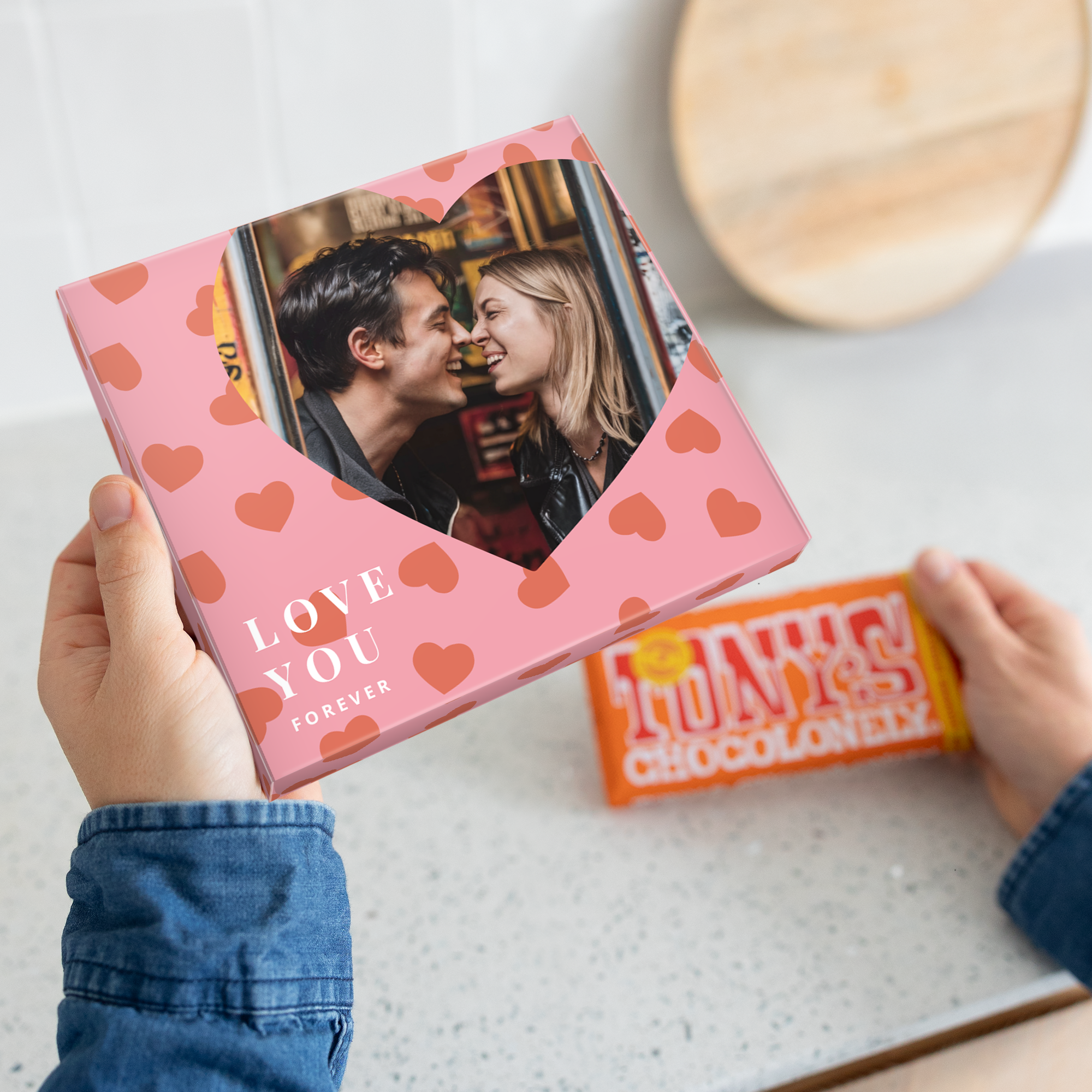 Käsin pidetty Tony's Chocolonely -suklaalahjarasia omalla kuvalla ja tekstillä "LOVE YOU FOREVER" painettuna.