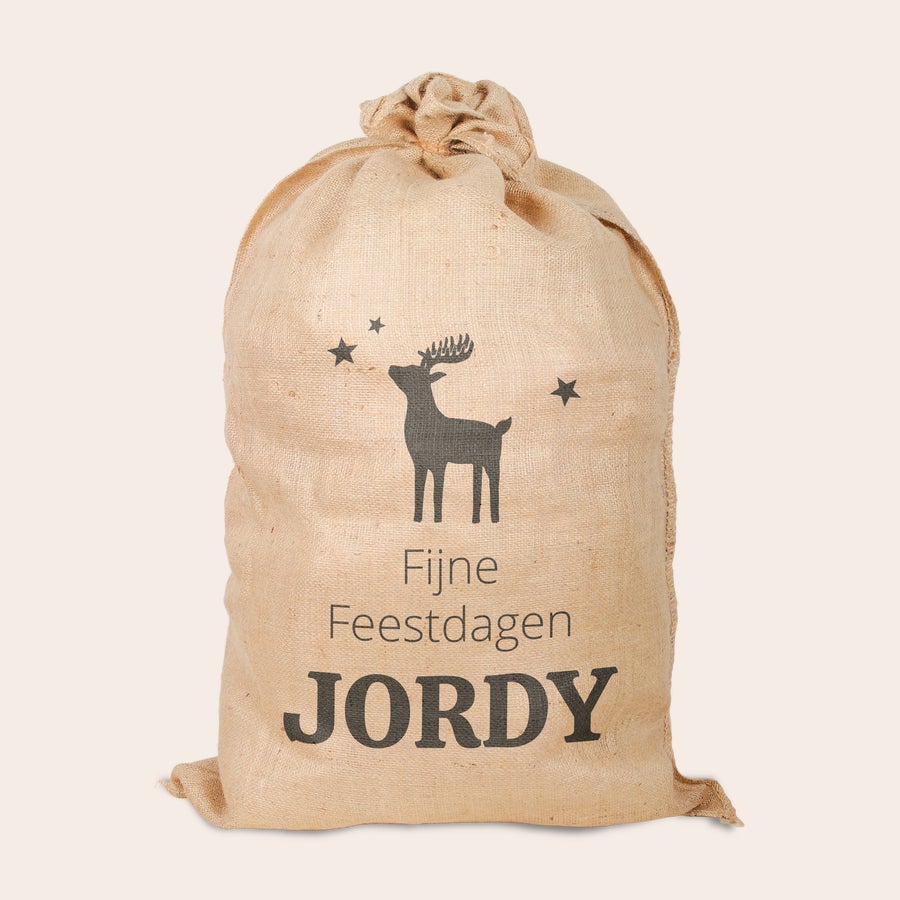 Jute kerstzak met naam bedrukt Jute kerstzak bedrukt met rendier, sterren en de tekst "Fijne Feestdagen Jordy"