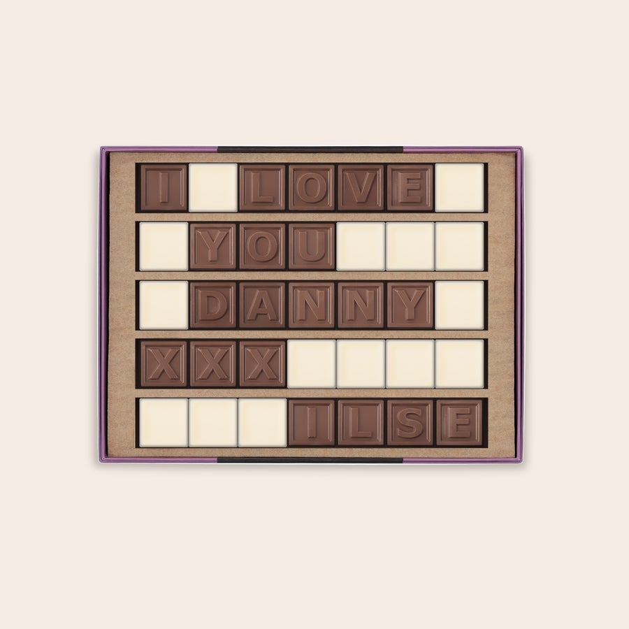 Chocotelegram Persoonlijk chocotelegram met melkchocolade letters "I LOVE YOU DANNY XXX ILSE" en witte chocolade spaties in een cadeaudoosje.