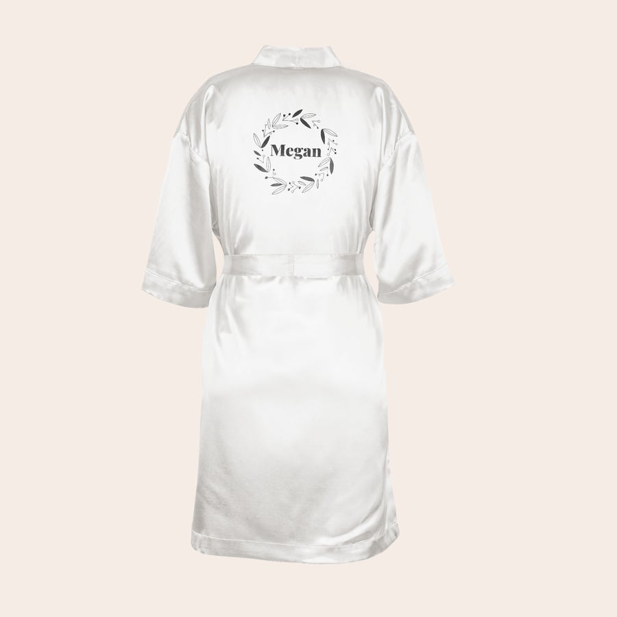 Kimono personalizat Kimono personalizat alb, imprimat cu numele Megan înconjurat de o coroniță de frunze, un cadou care surprinde.