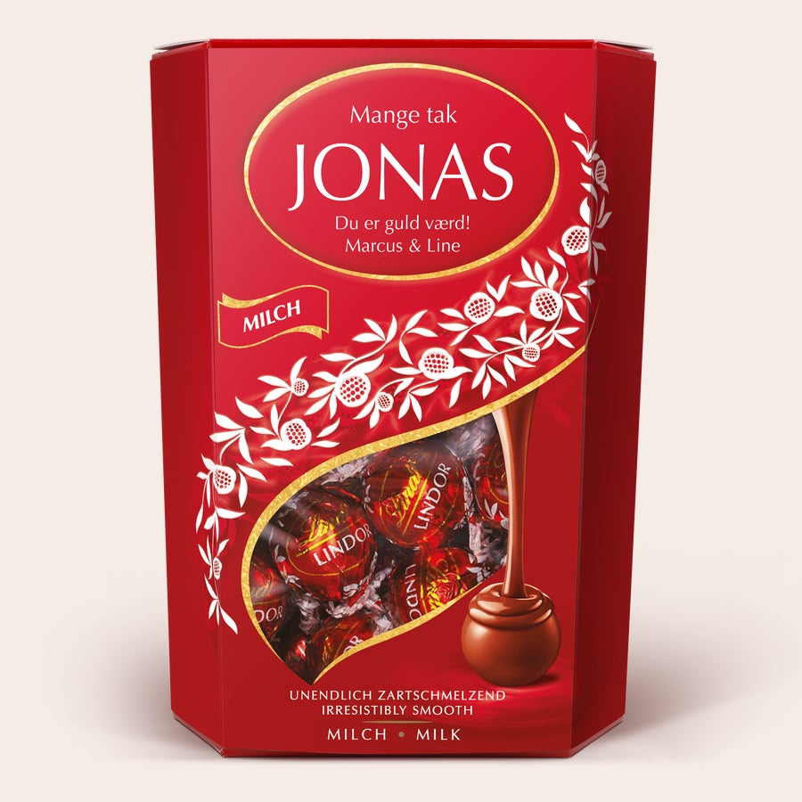 Gaveæske med Lindt-chokolade Personlig Lindt Chokolade gaveæske i rød med hvidt blomstermønster og navnet JONAS trykt i guld, perfekt til chokolade elskere.