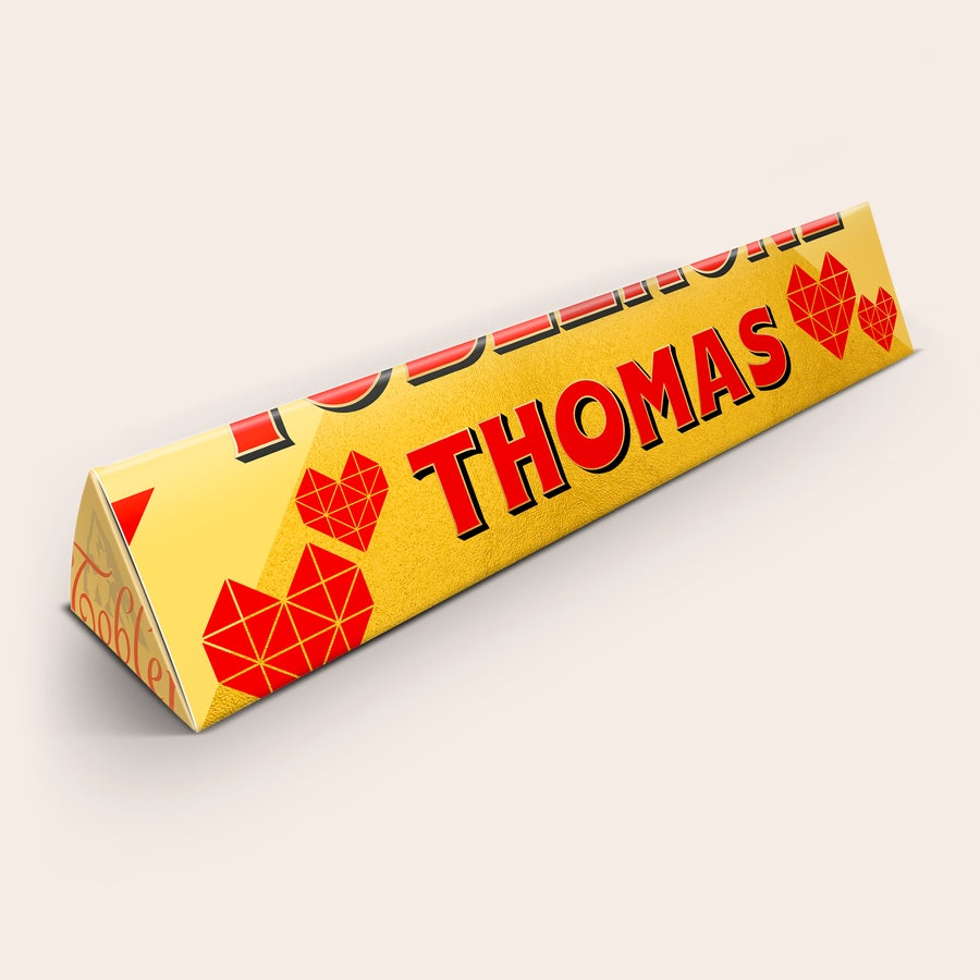 Personalizovaná Toblerone - Láska Personalizovaná Toblerone čokoláda s menom Thomas vytlačeným na žltom obale s červenými srdiečkami.
