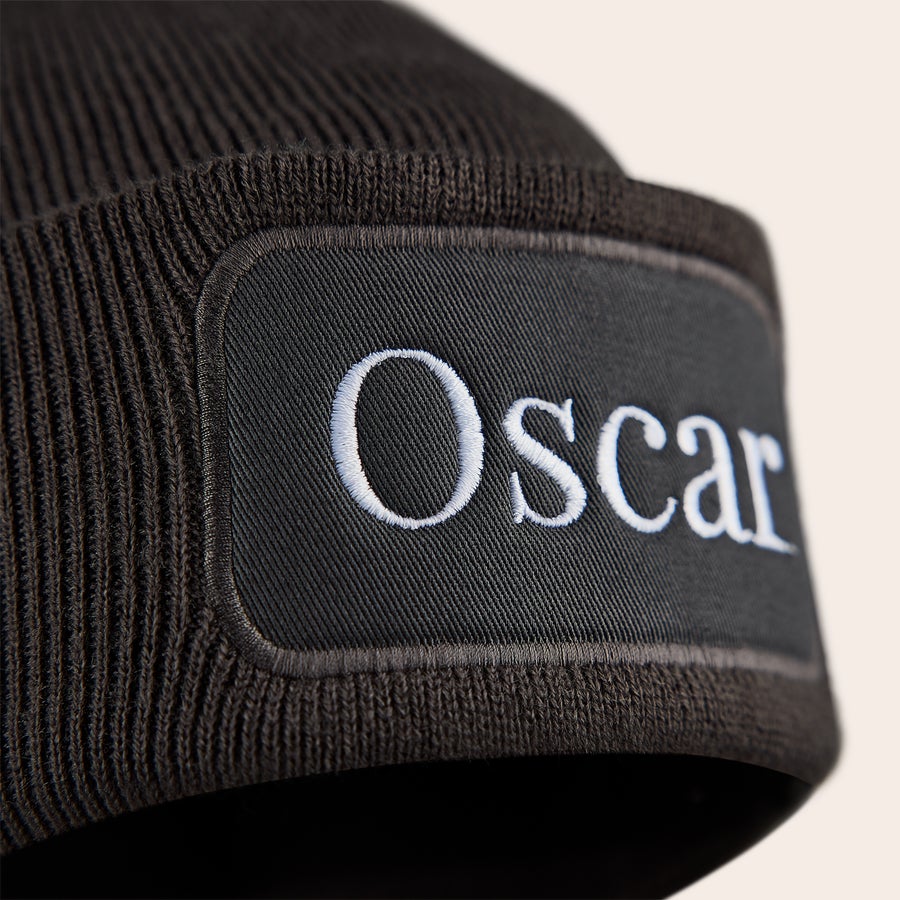 Broderad hatt Svart personlig beanie med namnet Oscar broderat i vitt på en tyglapp, håll de små öronen varma med en cool mössa.