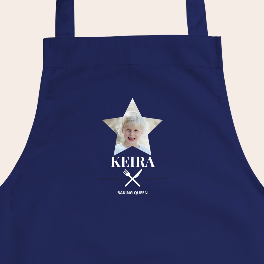 Barnas forkle Mørkeblått barneforkle med stjernetrykk, et bilde av et smilende barn, navnet KEIRA og teksten BAKING QUEEN.