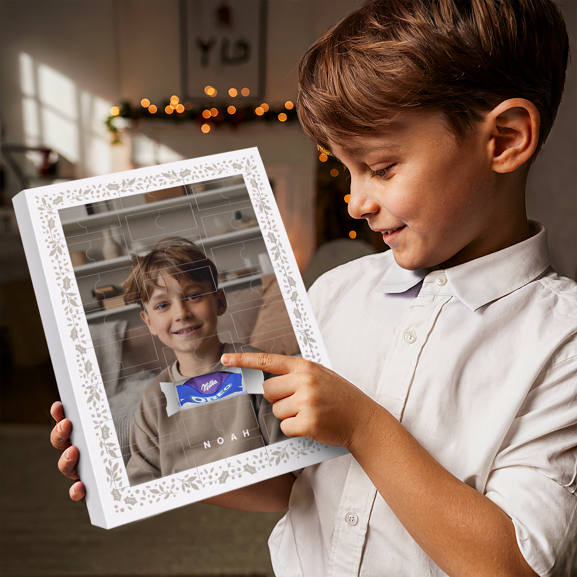 Ein Junge freut sich über einen personalisierten Adventskalender mit seinem Foto, dem Namen Noah und Milka Schokolade, um bis Weihnachten runterzuzählen.