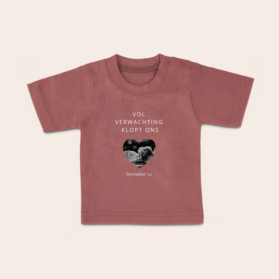 Baby shirt bedrukken Baby shirt met naam. Oudroze baby shirt bedrukt met echofoto in hartvorm, de tekst Vol Verwachting Klopt Ons en de datum December '22.