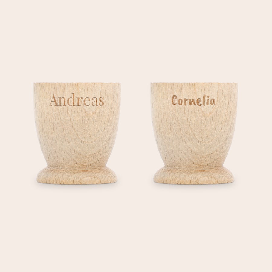 Personifierad äggkopp Två personliga äggkoppar i bokträ, graverade med namnen Andreas och Cornelia. Gör frukosten minnesvärd med personliga äggkoppar.
