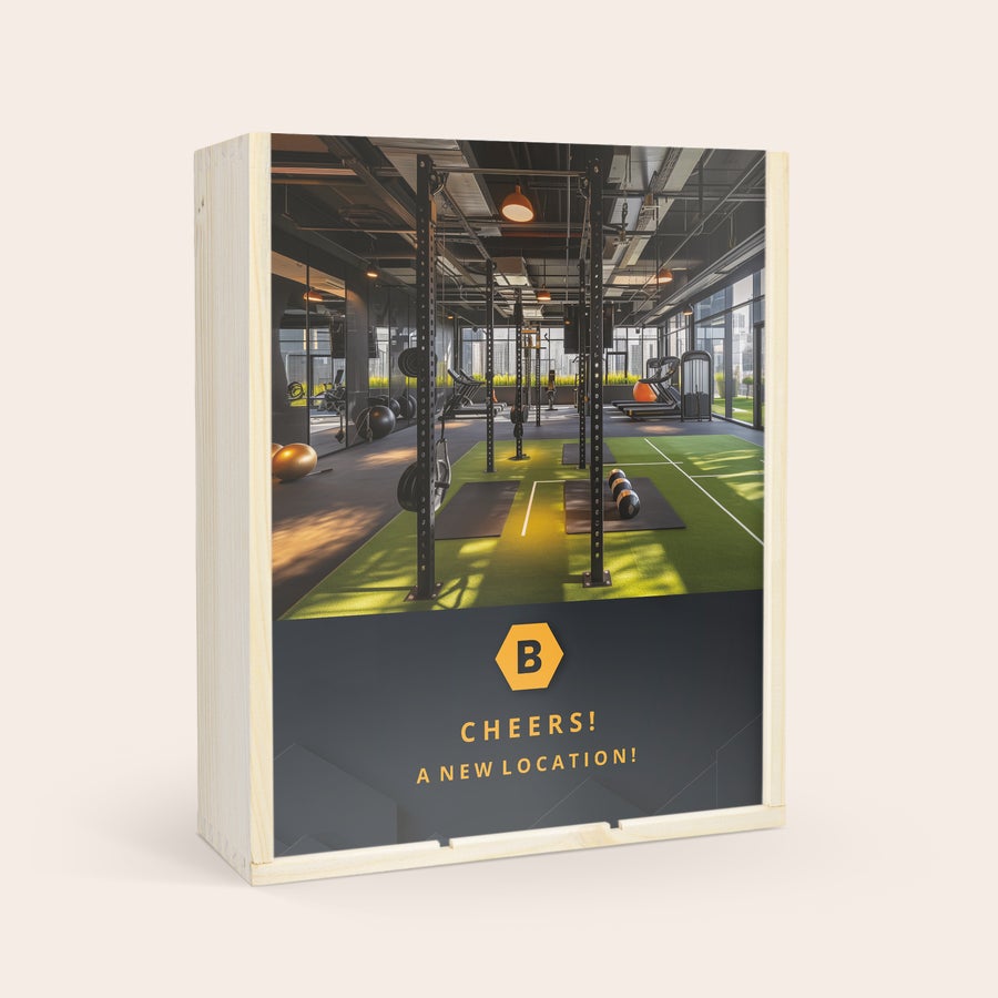 Salentein Chardonnay Personalizzato Set regalo di vino personalizzato con cassa in legno e coperchio scorrevole stampato. Il coperchio mostra una palestra e la scritta "Cheers! A New Location!". Farai certamente punti con questo delizioso set regalo di vino con coperchio stampato.