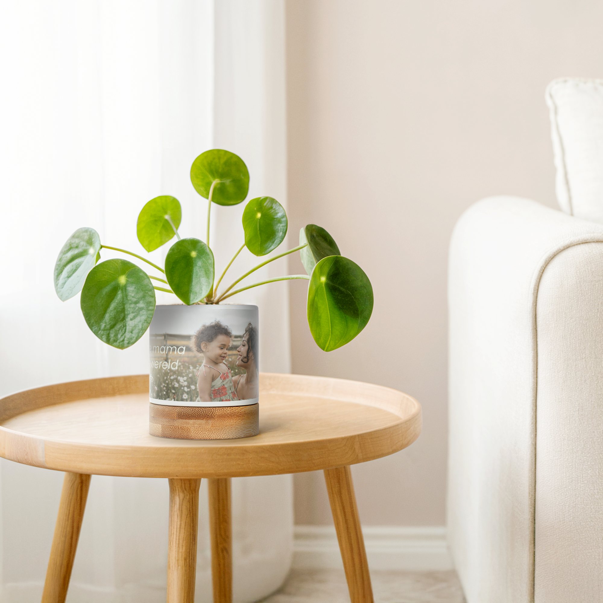 Witte bloempot met bamboe onderzetter, bedrukt met een foto van moeder en kind, en de tekst 'Liefste mama van de wereld' om hun groen een persoonlijk tintje te geven.