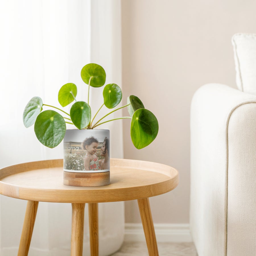 Bloempot met foto Witte bloempot met bamboe onderzetter, bedrukt met een foto van moeder en kind, en de tekst 'Liefste mama van de wereld' om hun groen een persoonlijk tintje te geven.
