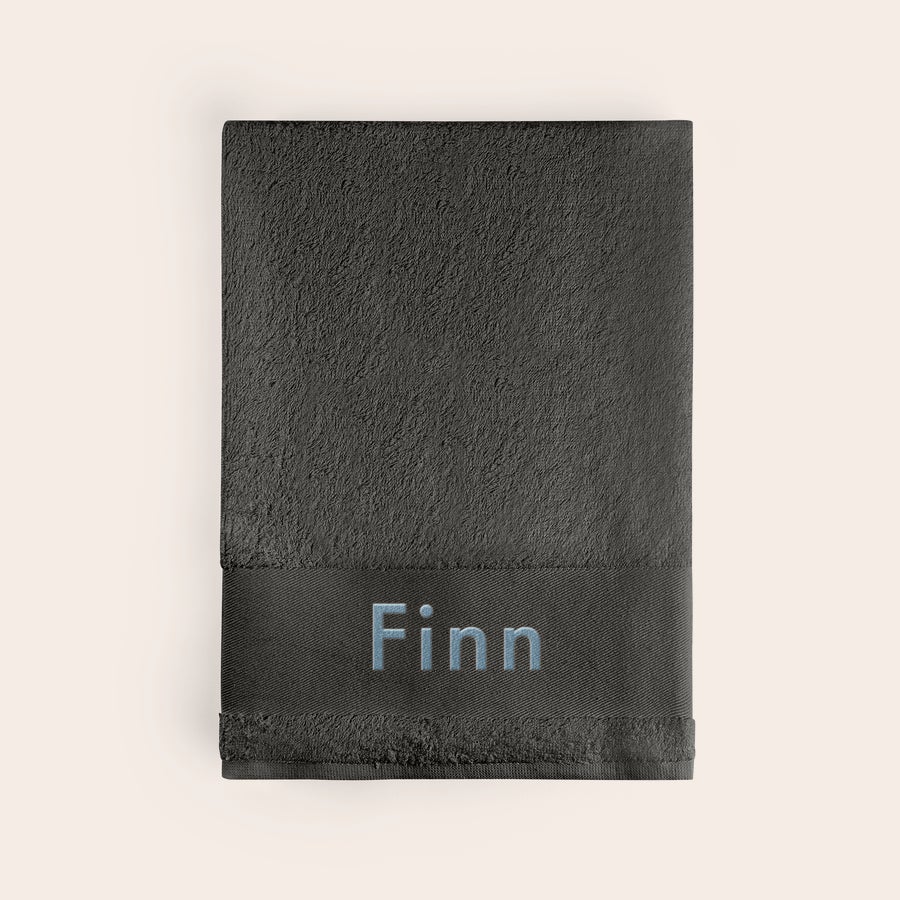 Handtuch mit Namen Dunkelgraues Handtuch besticken mit dem Namen Finn in hellblauer Schrift