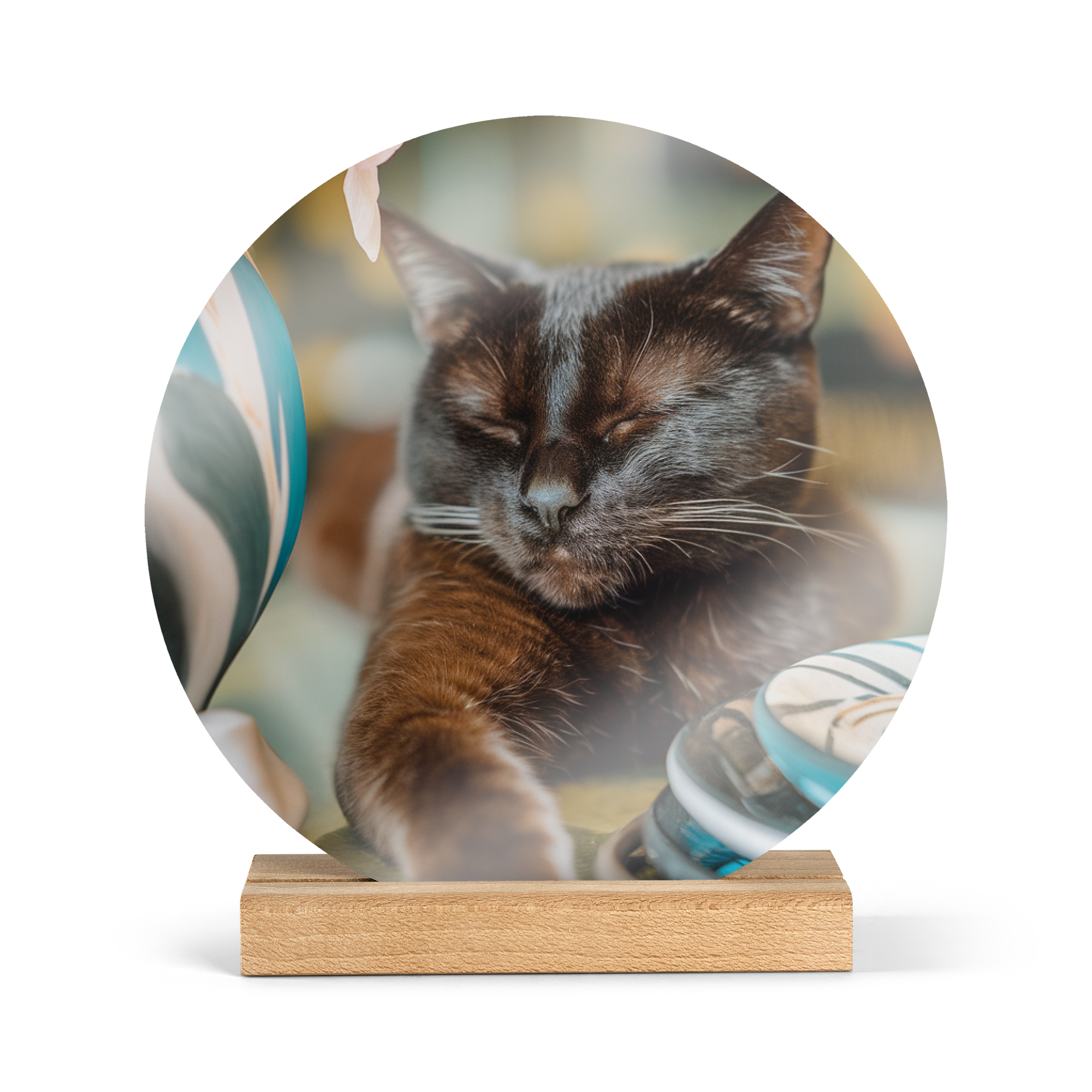 A personalized round wooden photo tile with a glossy finish printed with a sleeping black cat on a wooden display stand. Turn your favourite memory into a stunning round display.