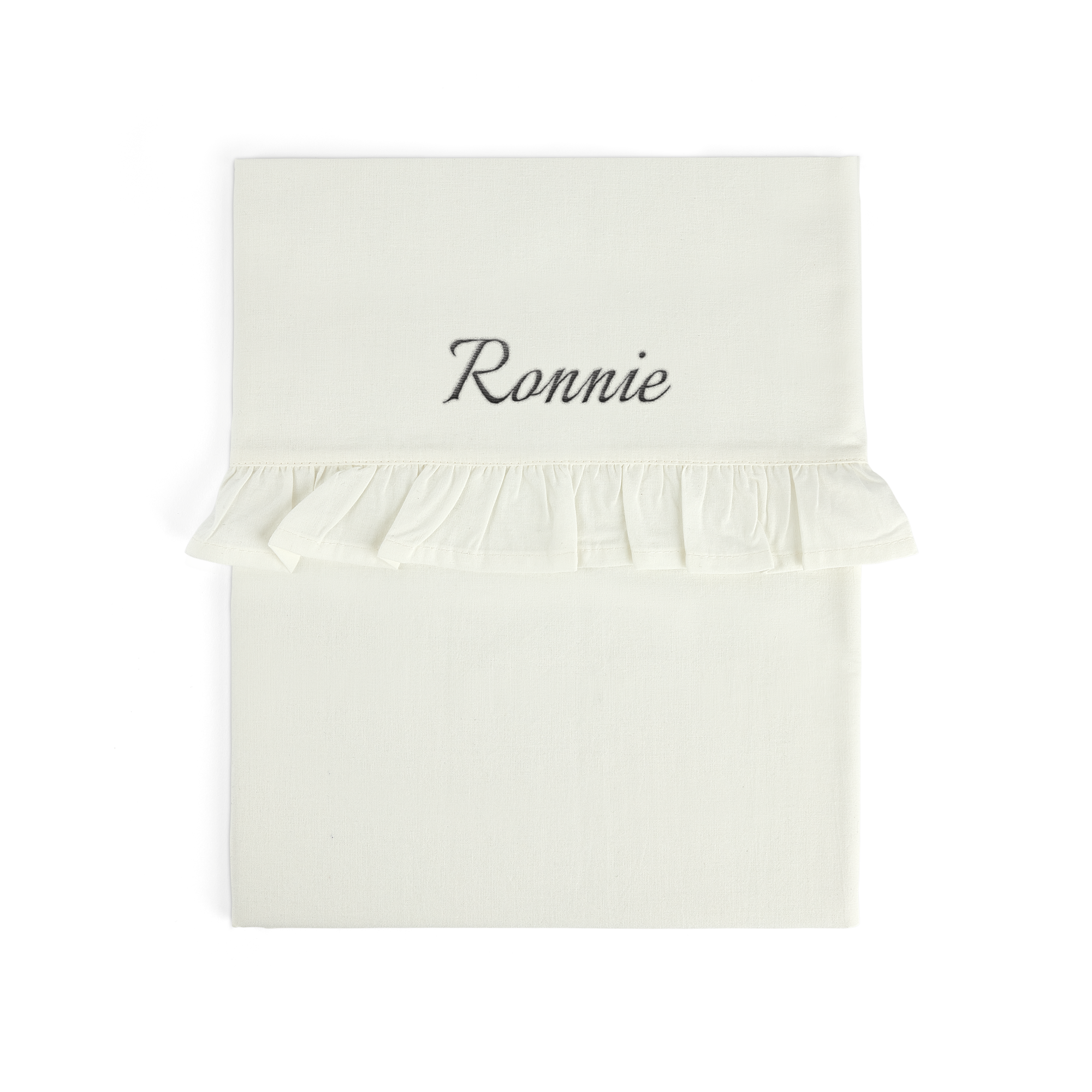 Cream personalized embroidered cot sheet with the name Ronnie in script font and a ruffled edge
