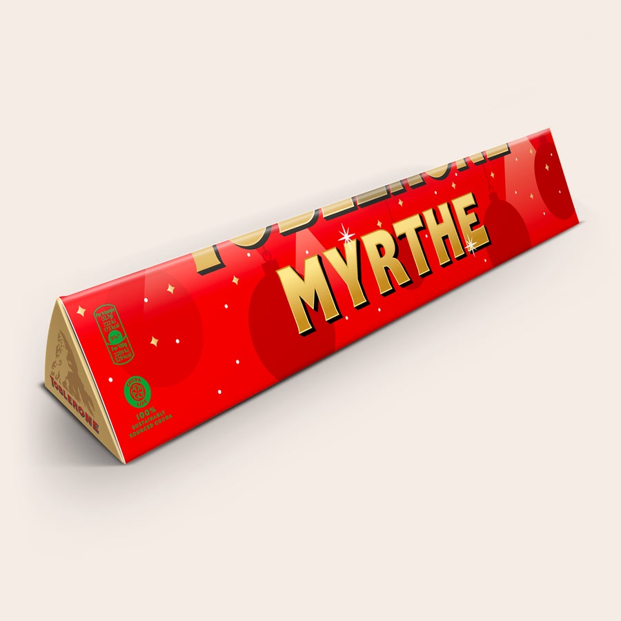 Toblerone XXL bedrukken Persoonlijke XXL Toblerone reep met rode feestelijke wikkel, goudkleurige kerstballen en naam Myrrthe.