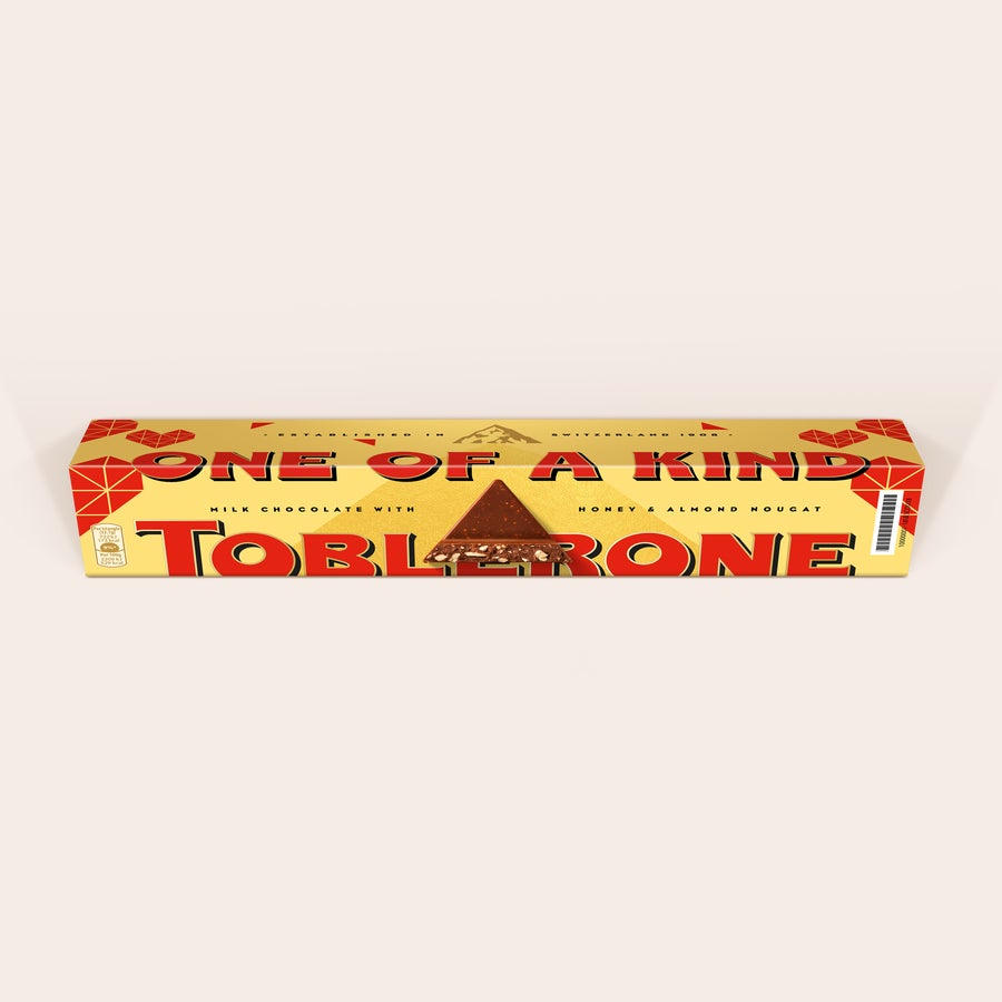 Personalizovaná Toblerone - Láska Personalizovaná Toblerone čokoláda s nápisom ONE OF A KIND a zobrazeným kúskom čokolády s orieškami, potlačená vlastnou fotografiou alebo textom.