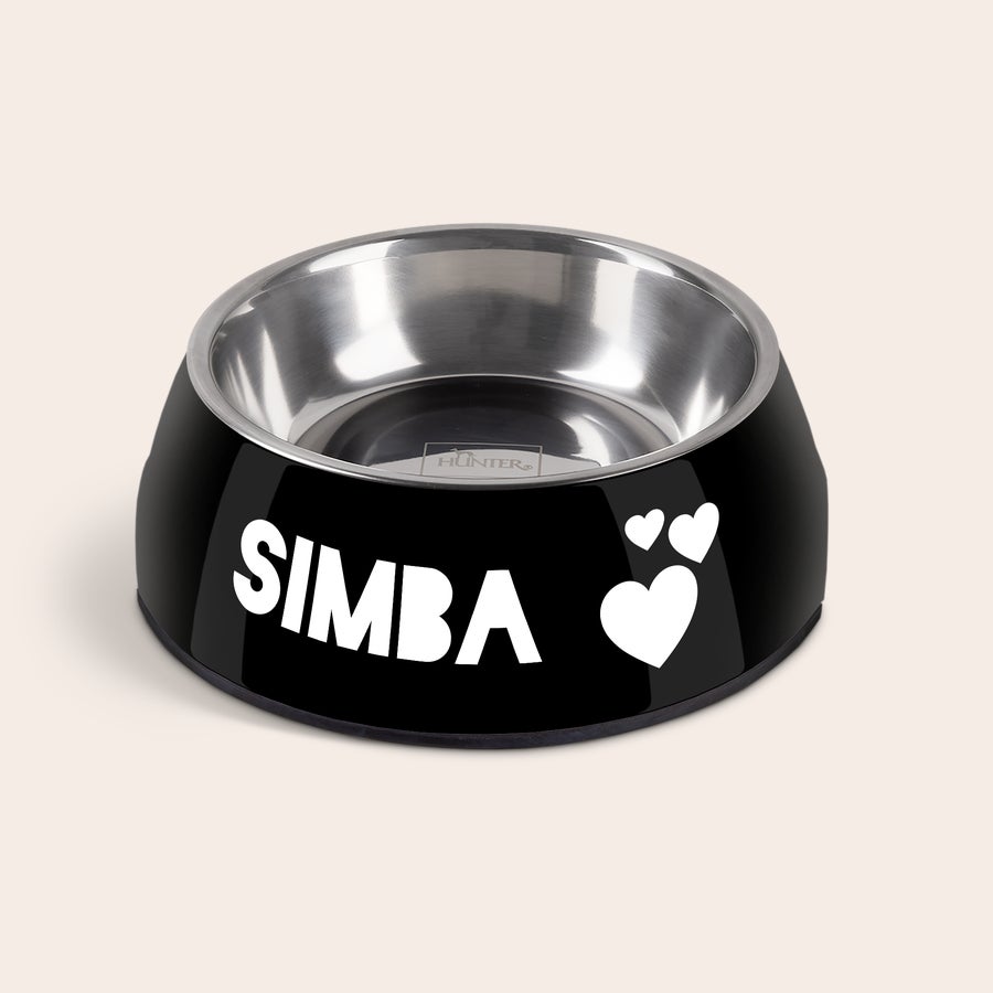 Hundmatskål Svart personlig matskål med en avtagbar insats i rostfritt stål. Skålen är tryckt med texten SIMBA och tre vita hjärtan.